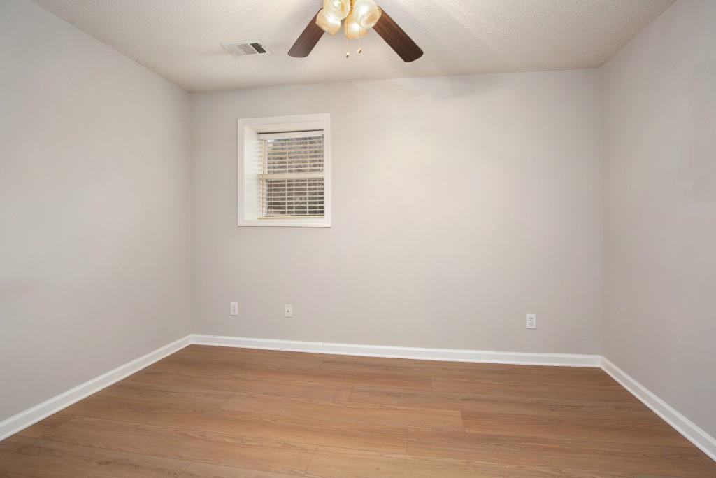 8440 River Bluff Place Ball Ground, GA 30107 - Photo 45 of 73 an empty room with wooden floor and windows