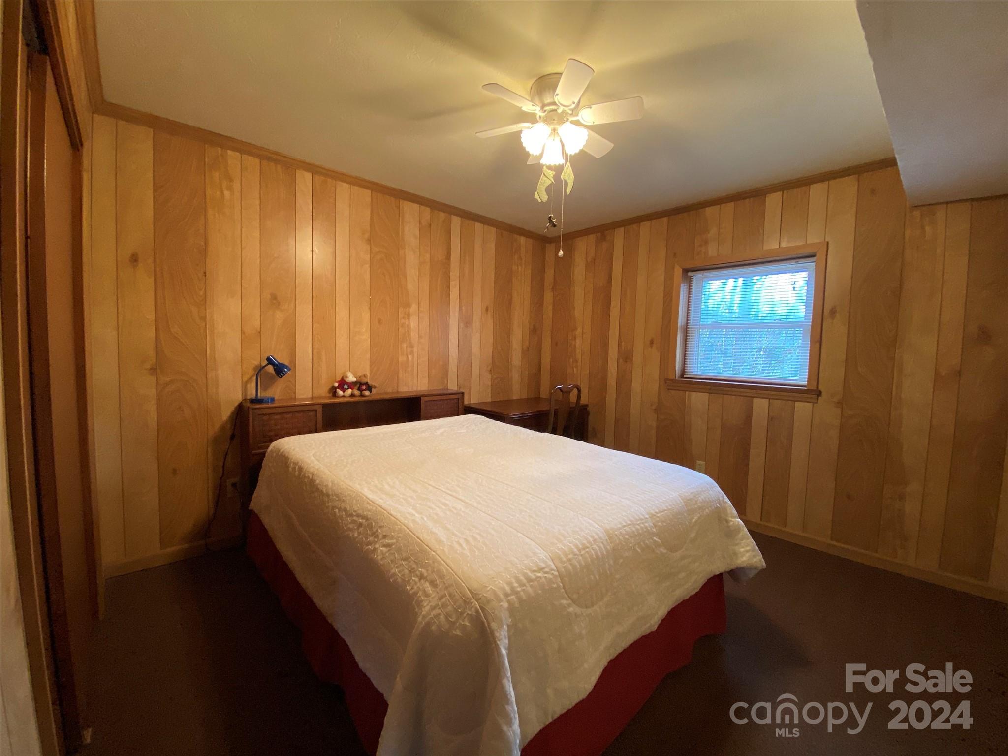 344 Pine Ridge Trail Almond, NC 28702 - Photo 18 of 34 a bed sitting in a bedroom next to a window and a chandelier