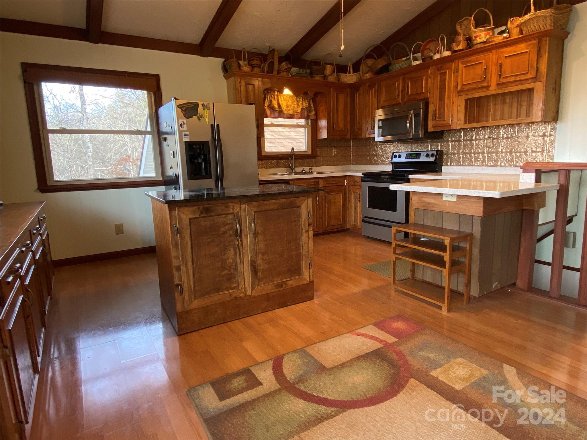 344 Pine Ridge Trail Almond, NC 28702 - Photo 4 of 34 a kitchen with stainless steel appliances kitchen island granite countertop a stove a sink and a microwave