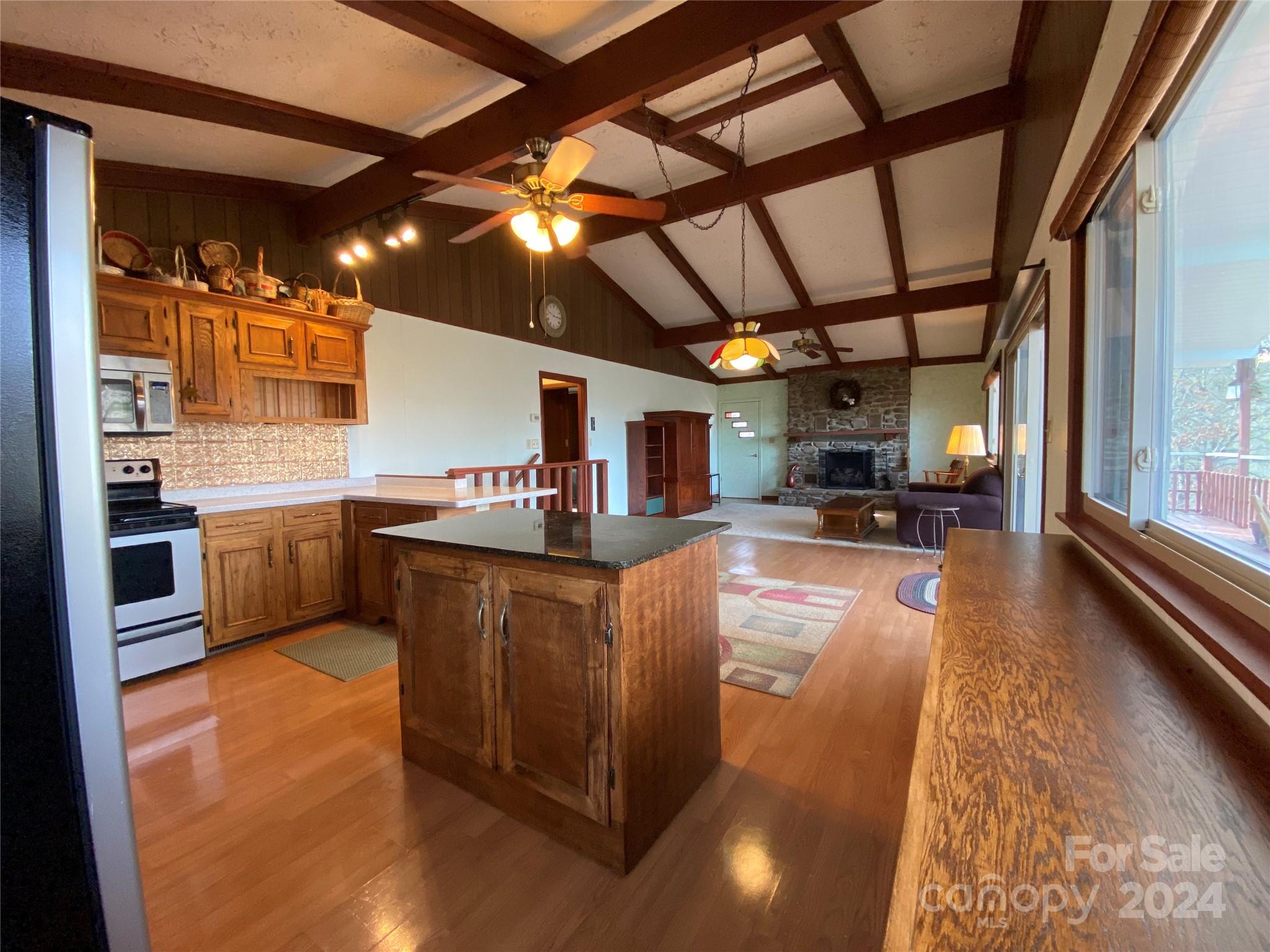 344 Pine Ridge Trail Almond, NC 28702 - Photo 7 of 34 a kitchen with stainless steel appliances granite countertop a sink a stove top oven a chimney and a center island