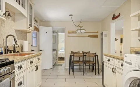 a very nice looking kitchen with granite countertop a sink stainless steel appliances and cabinets