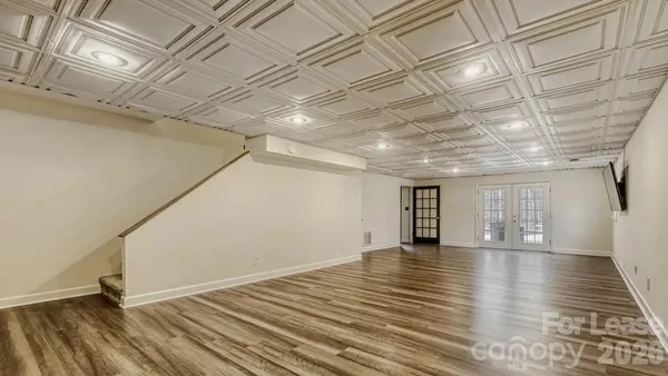 a view of empty room with wooden floor