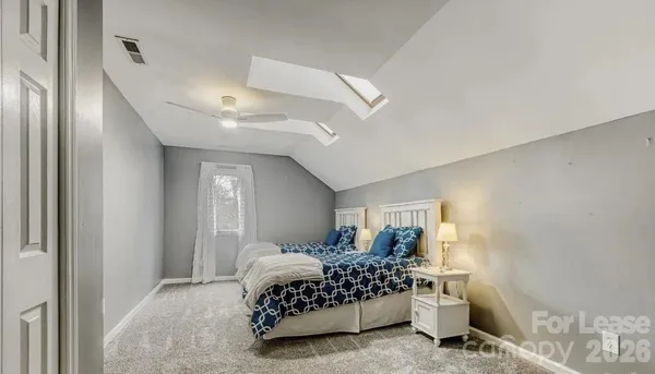 a bedroom with a bed rug and lamp