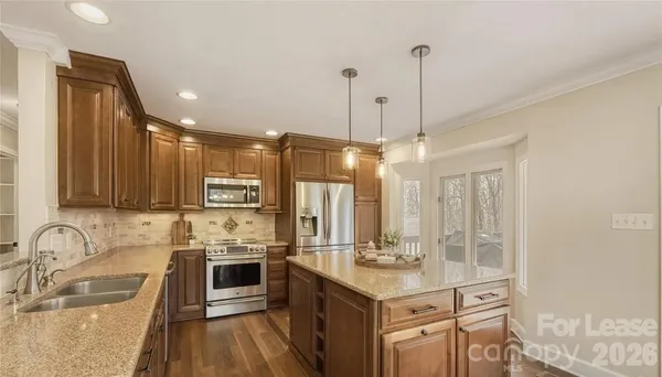 a kitchen with stainless steel appliances granite countertop a sink stove and refrigerator