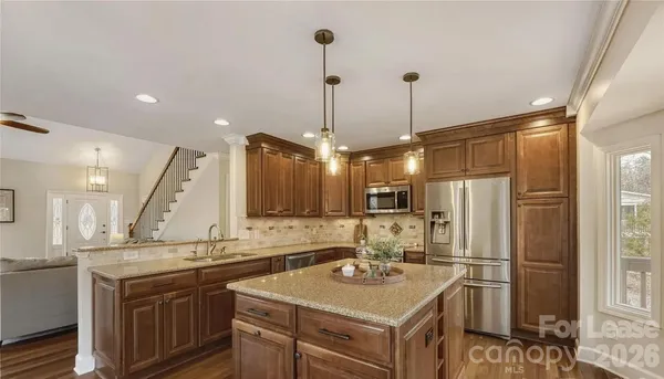a kitchen with a sink a counter space appliances and cabinets
