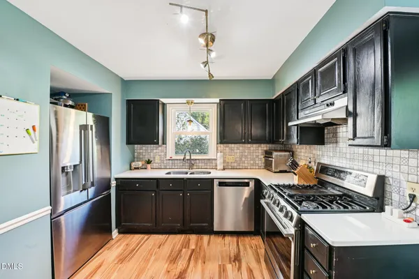 a kitchen with stainless steel appliances a sink stove and refrigerator