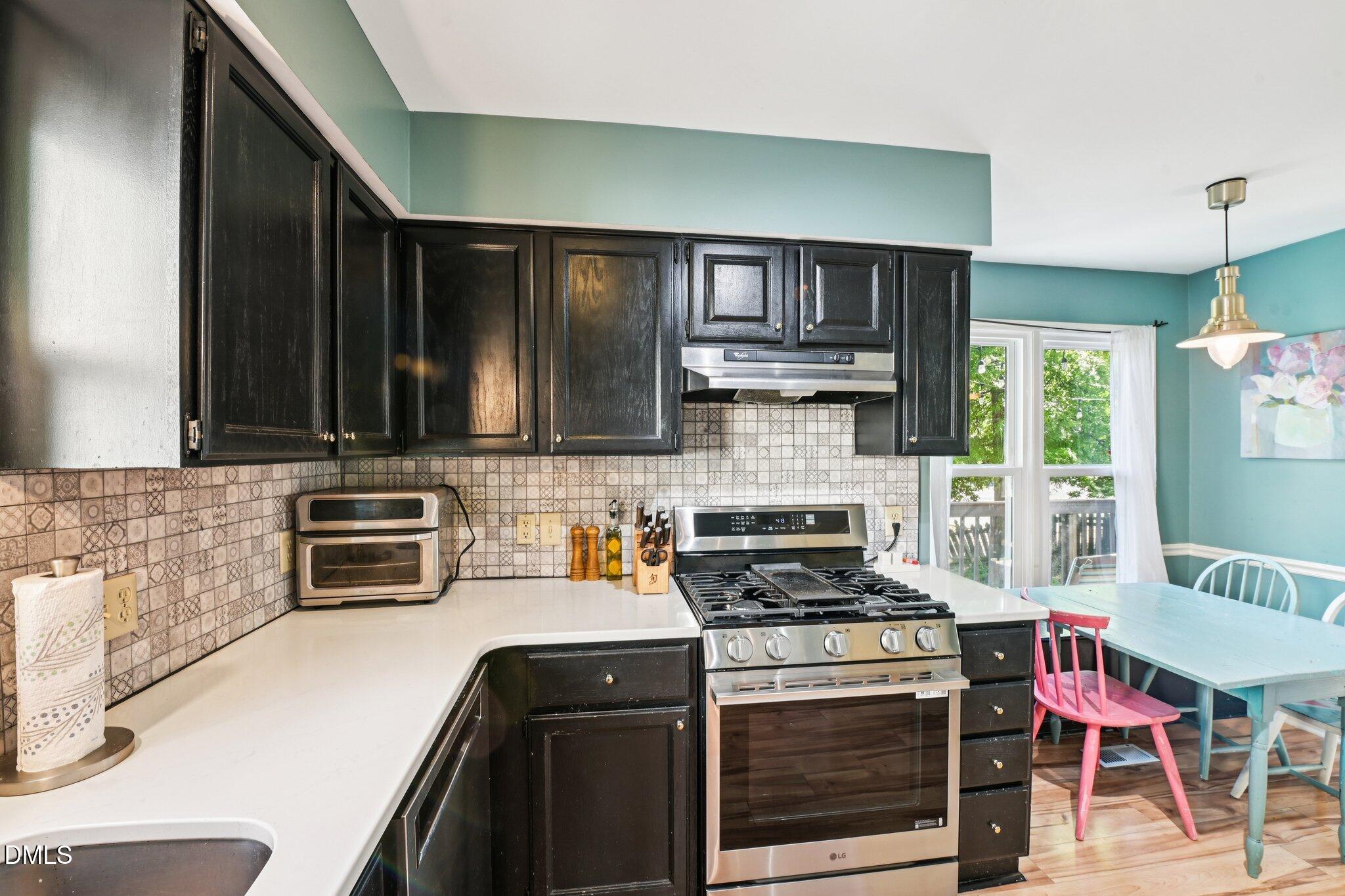 4508 Emmit Drive Raleigh, NC 27604 - Photo 13 of 42 a kitchen with stainless steel appliances a stove a sink cabinets and a wooden floor