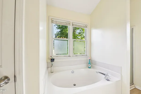 a white bath tub sitting in a bathroom next to a window