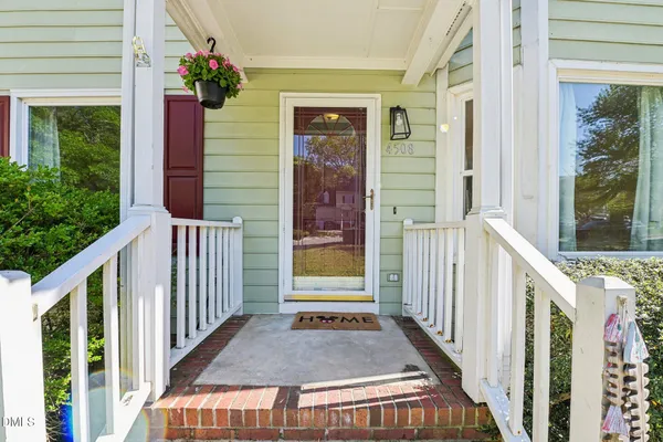 a view of a porch with wooden floor and front door