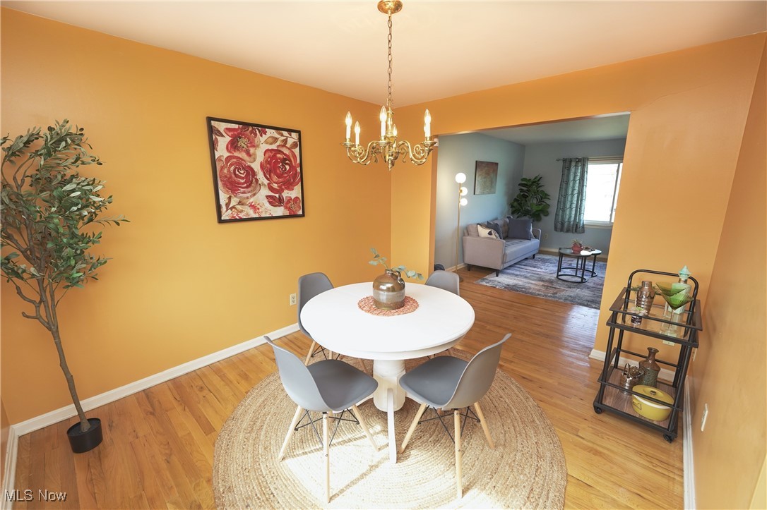 2674 Smith Road Fairlawn, OH 44333 - Photo 11 of 31 Dining space featuring light wood finished floors, baseboards, and a notable chandelier