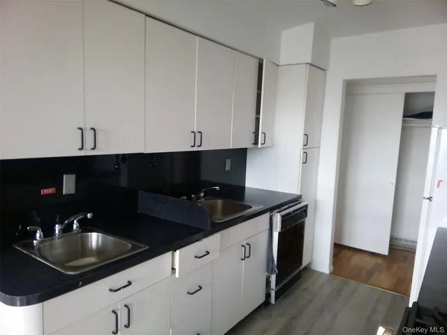 a kitchen with granite countertop white cabinets and a sink
