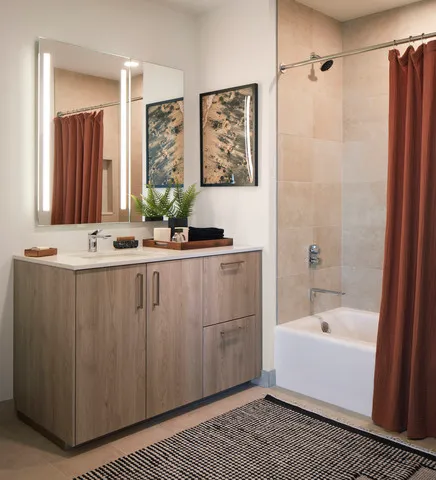 a bathroom with a tub a sink and a mirror