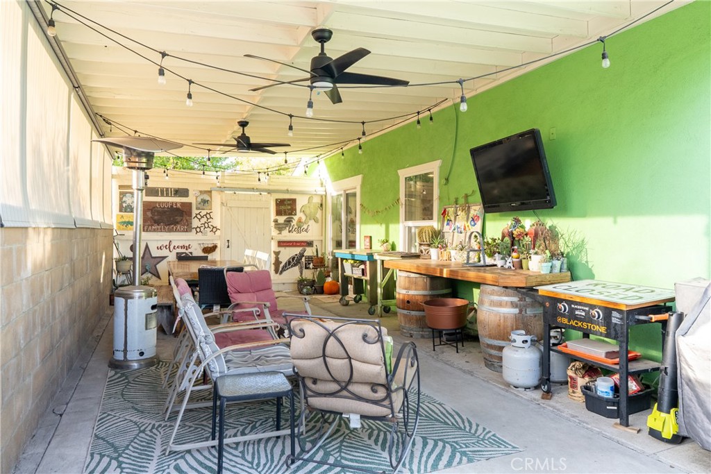 8892 Palomar Avenue Atascadero, CA 93422 - Photo 31 of 49 Patio 2 features a covered space with a concrete floor, ceiling fan, roll-up shades, and café lighting, ideal for relaxing or entertaining in style.