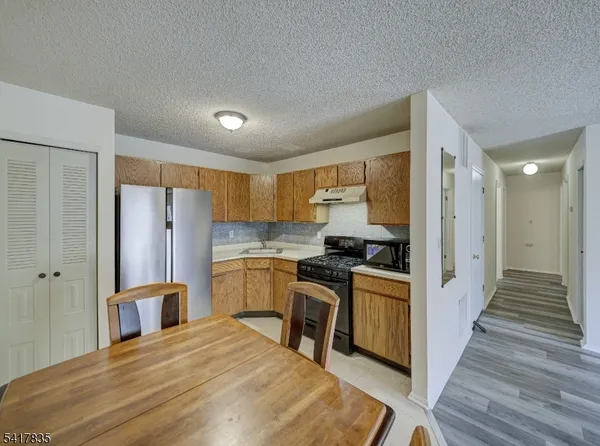 a kitchen with stainless steel appliances granite countertop a stove refrigerator and cabinets