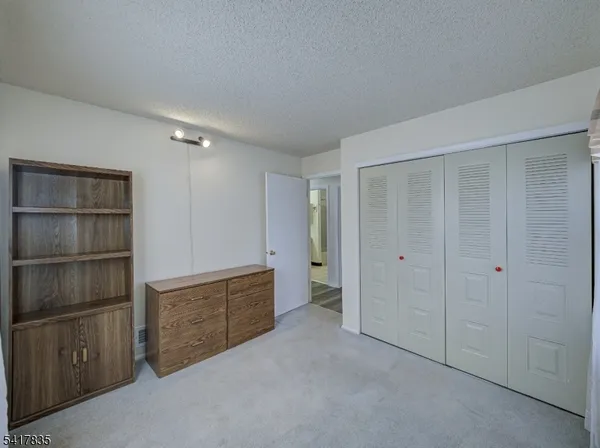 a view of an empty room with cabinet and entryway