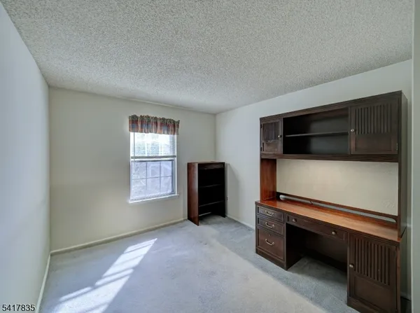 a living room with furniture flat screen tv and window