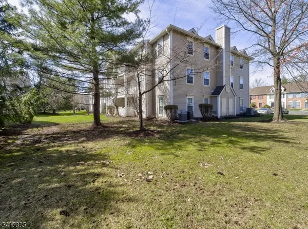 a view of a big building with a big yard and large trees
