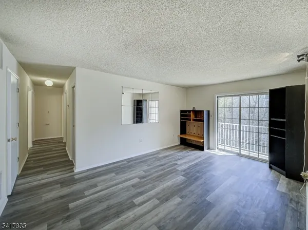 a view of a livingroom with wooden floor and a window
