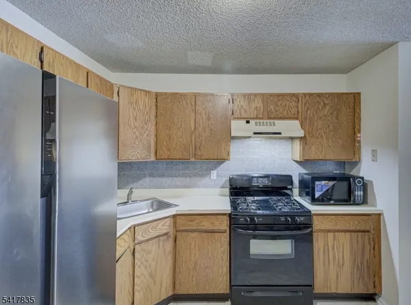 a kitchen with stainless steel appliances granite countertop a stove and a refrigerator