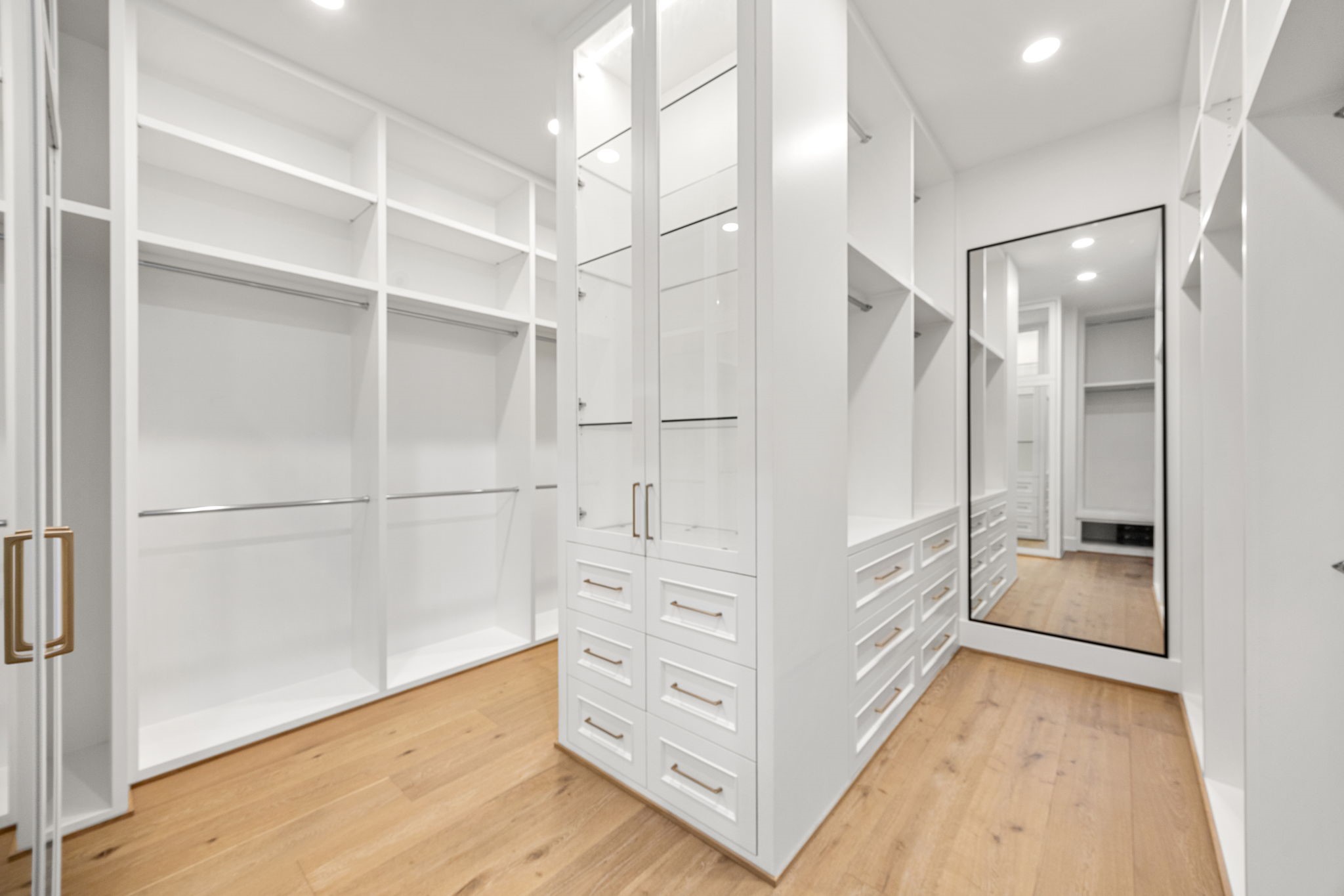 1032 West 41st Street Houston, TX 77018 - Photo 30 of 46 Large walk-in closet offers custom wardrobe built-ins w/ adjustable shelving for bags & shoes, glass front cabinets, 2 full size wall hung mirrors & separate mud room area w/ bench.