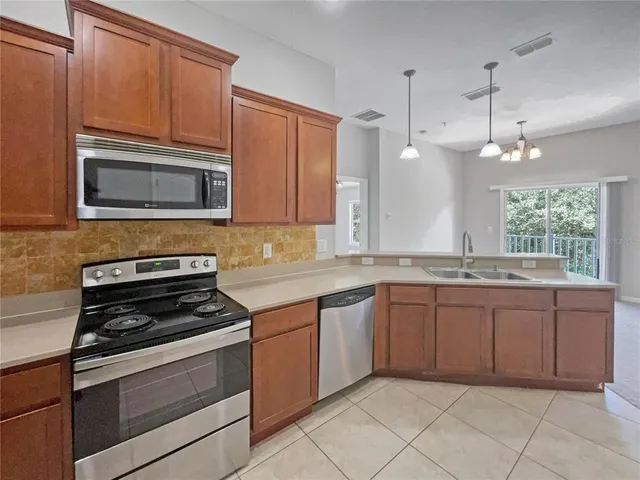 a kitchen with granite countertop a stove sink and microwave