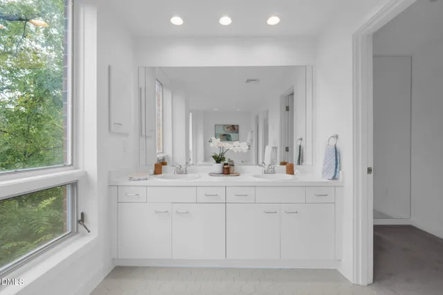 a bathroom with a double vanity sink mirror and shower
