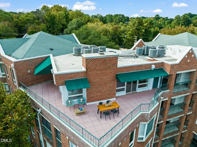 a view of a white building among the city and trees