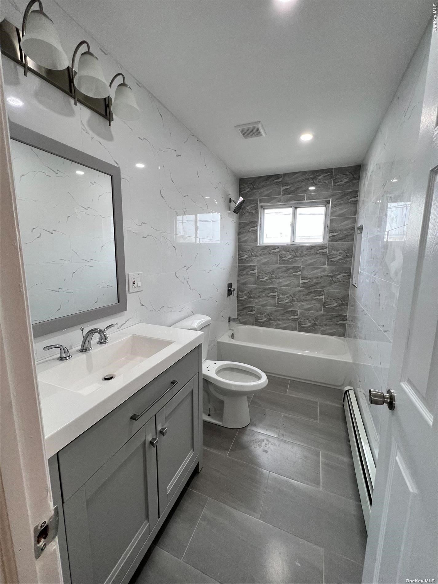a spacious bathroom with a double vanity sink a toilet and a mirror