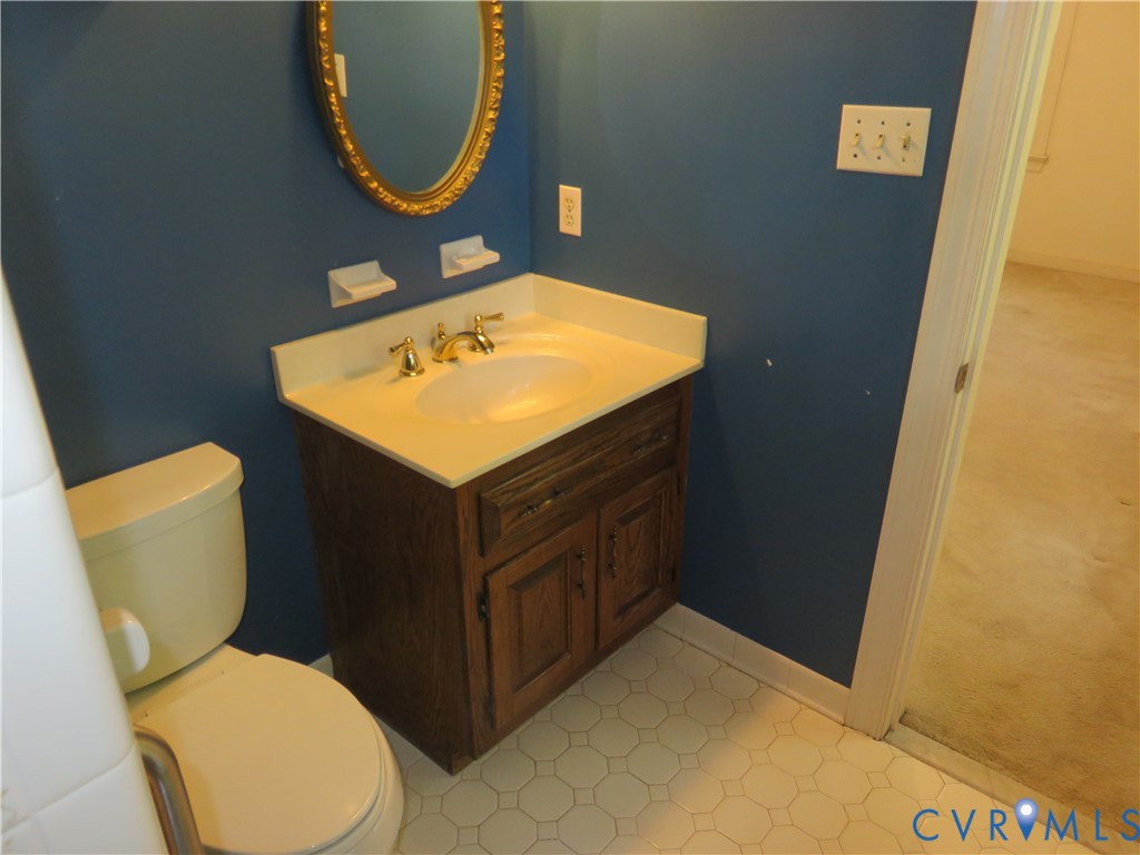 8379 Quailfield Road Mechanicsville, VA 23116 - Photo 42 of 56 a bathroom with a toilet a sink and a mirror