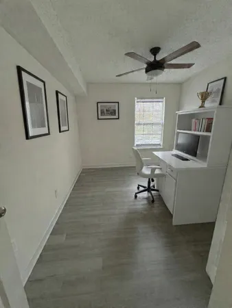 a view of a livingroom with workspace and a window