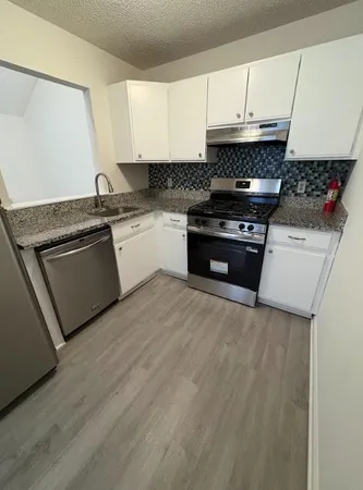 a kitchen with granite countertop a stove and a sink