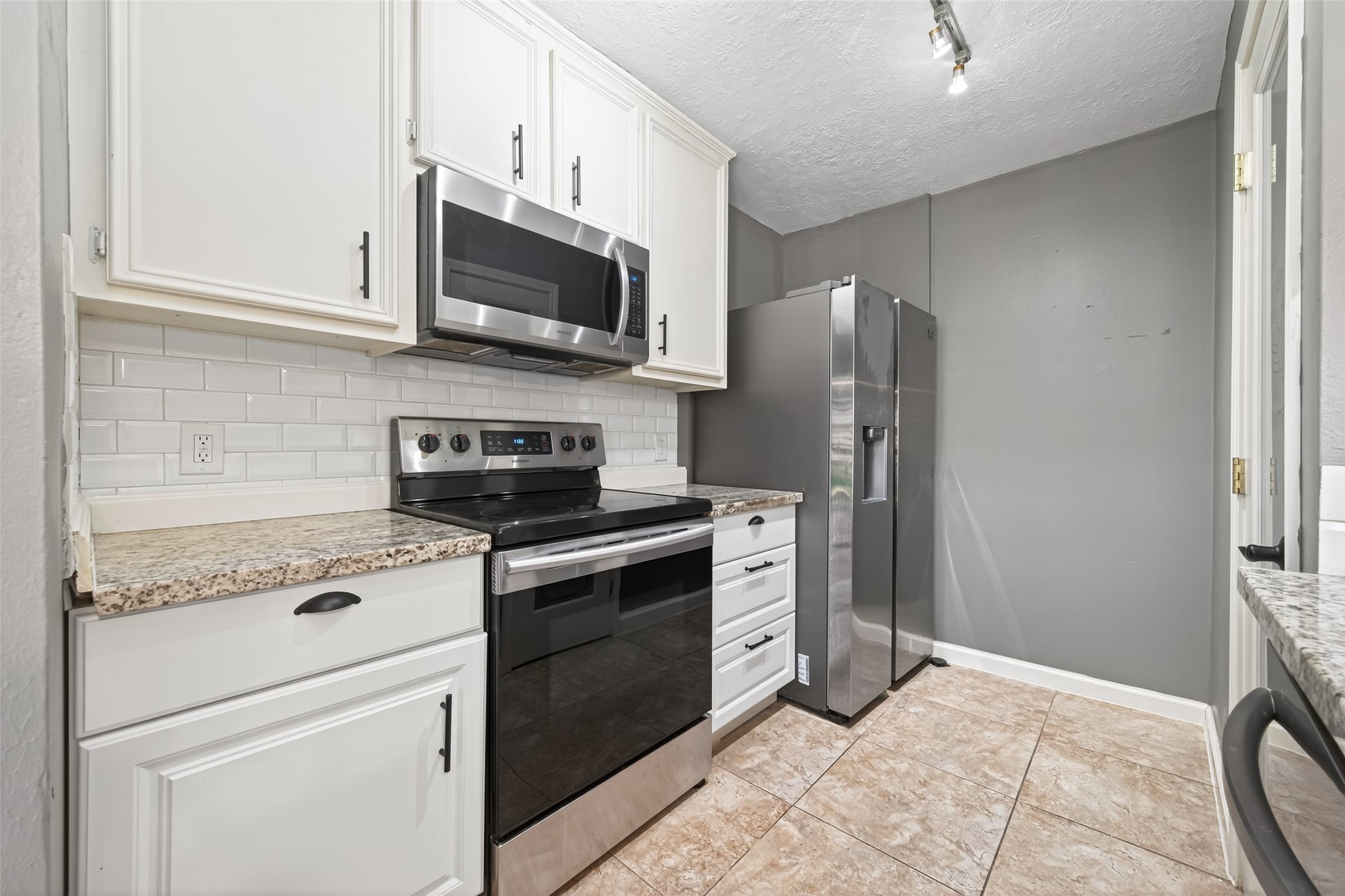 6700 Richardson Road, Unit 305 Houston, TX 77069 - Photo 15 of 46 a kitchen with stainless steel appliances granite countertop a stove a refrigerator and a microwave