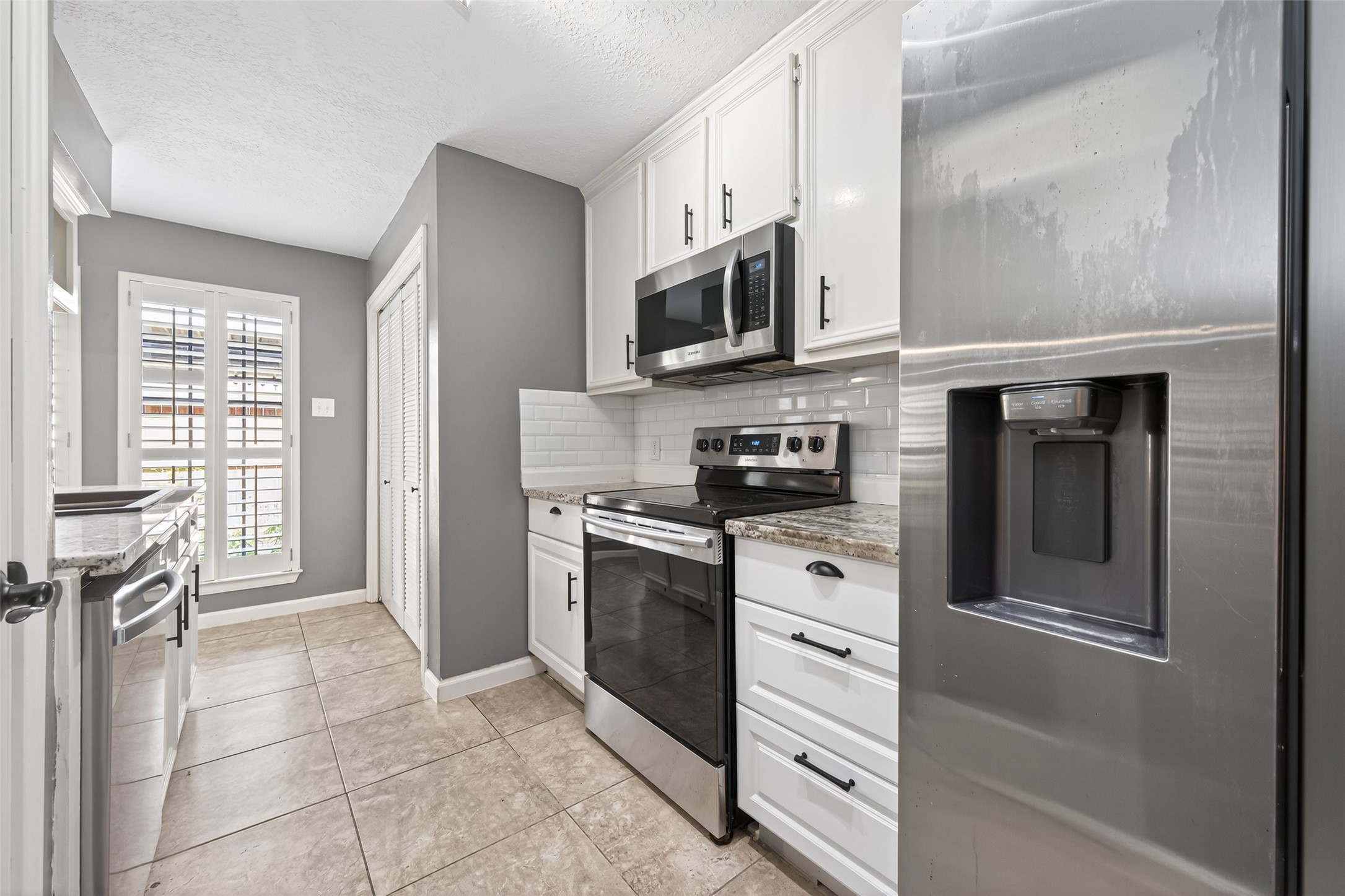 6700 Richardson Road, Unit 305 Houston, TX 77069 - Photo 17 of 46 a kitchen with stainless steel appliances white cabinets and a window