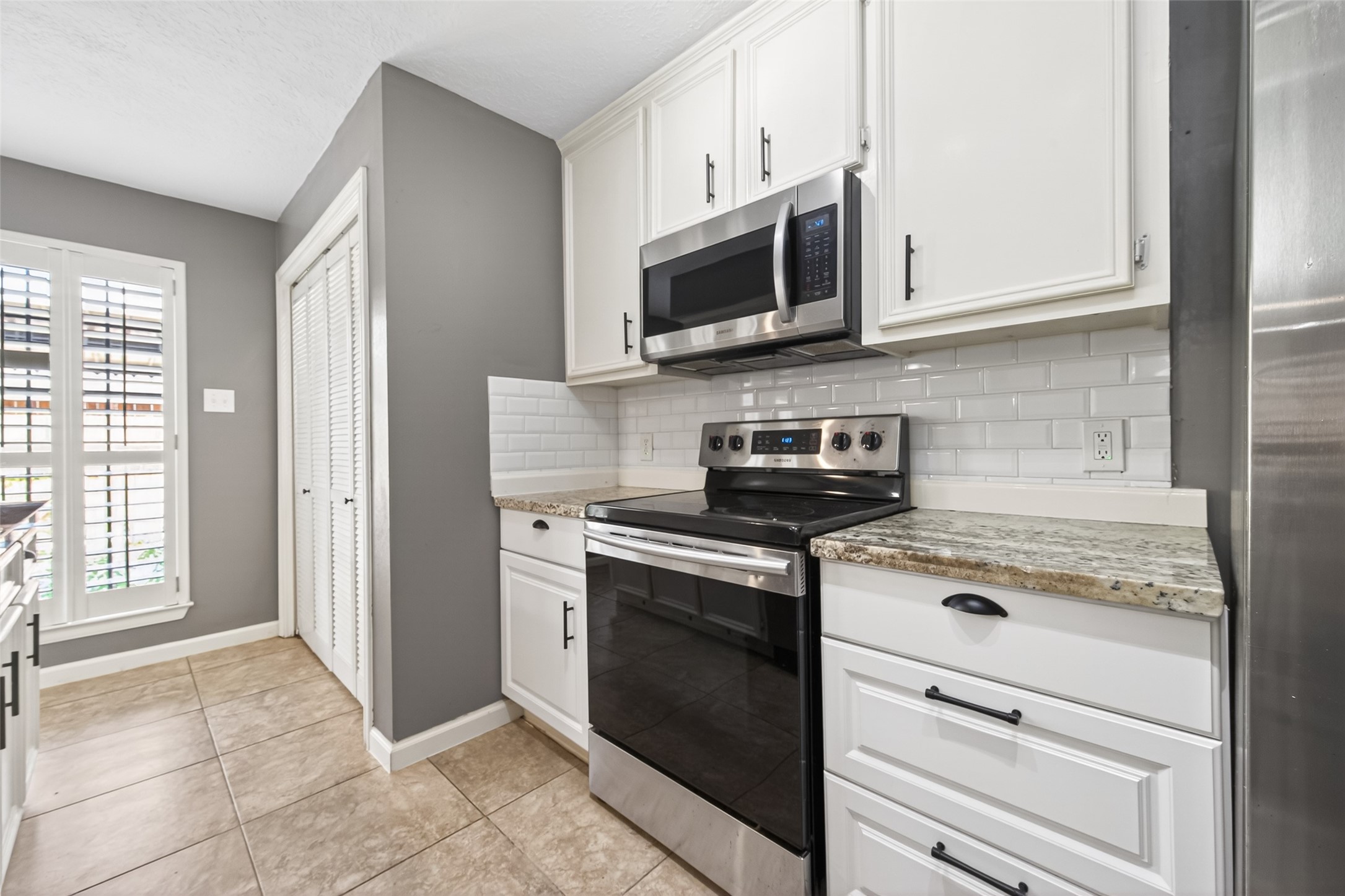 6700 Richardson Road, Unit 305 Houston, TX 77069 - Photo 18 of 46 a kitchen with stainless steel appliances granite countertop white cabinets and a stove