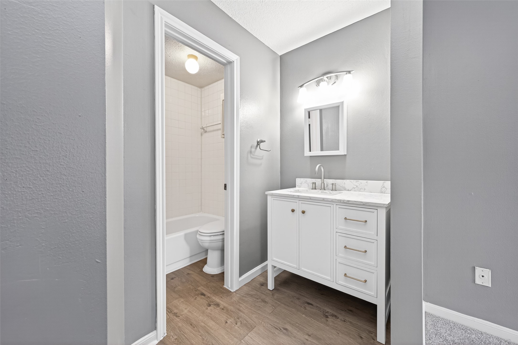6700 Richardson Road, Unit 305 Houston, TX 77069 - Photo 25 of 46 a bathroom with a granite countertop toilet a sink and a mirror