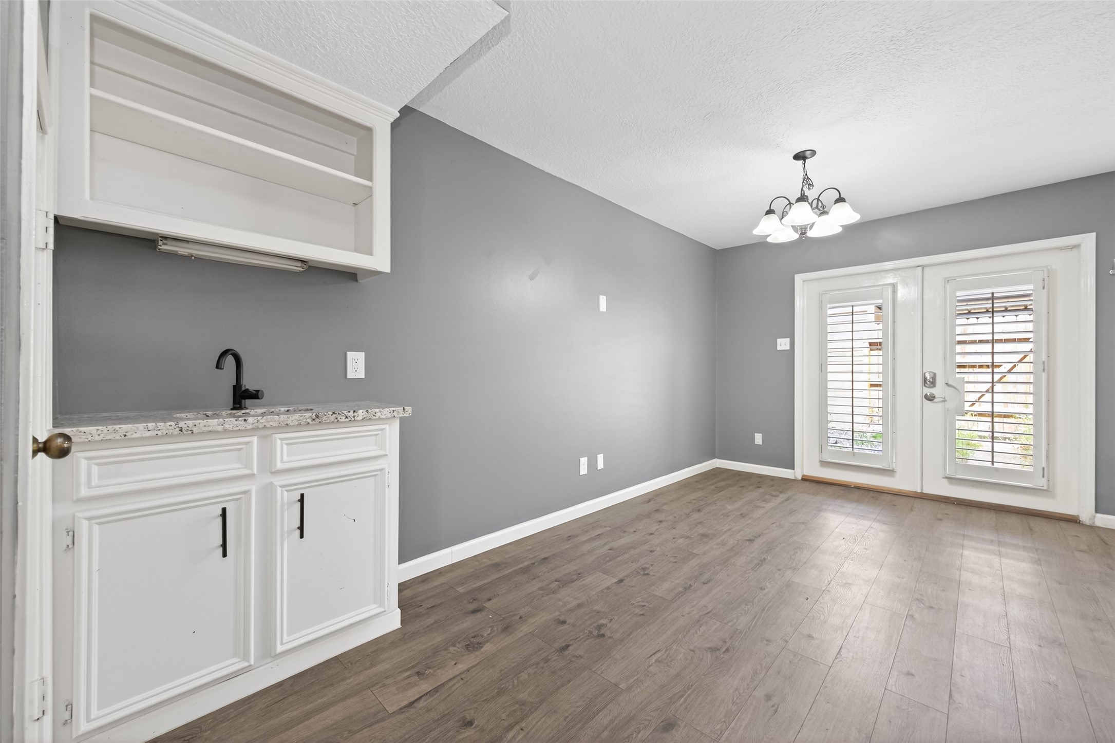 6700 Richardson Road, Unit 305 Houston, TX 77069 - Photo 8 of 46 a view of a kitchen with wooden floors and white cabinets