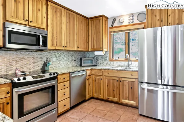 a kitchen with granite countertop a stove top oven microwave and cabinets