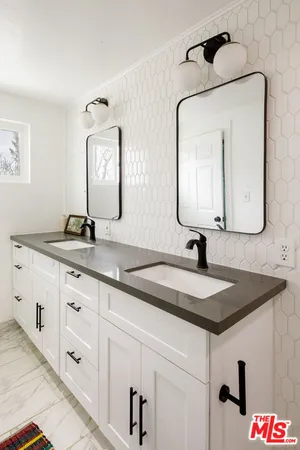 a bathroom with a granite countertop sink vanity and mirror