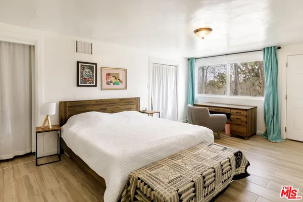 a bedroom with a large bed and a window