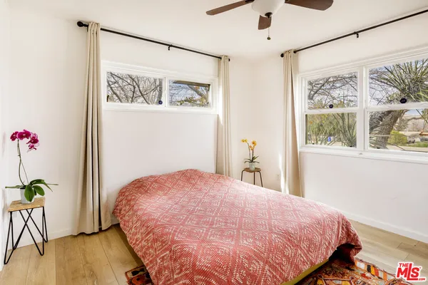 a bedroom with a bed and a wooden floor