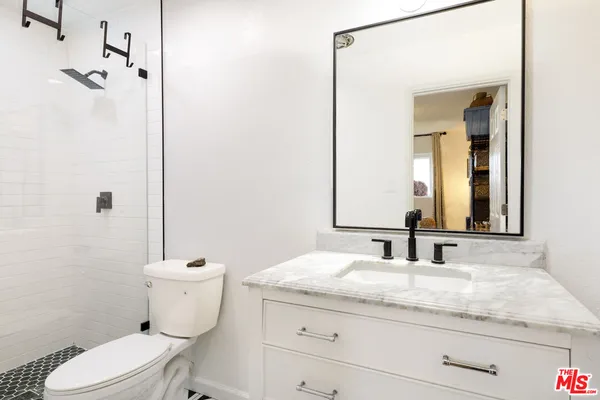 a bathroom with a granite countertop toilet sink and mirror