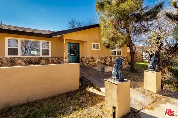 a view of a house with backyard and tree