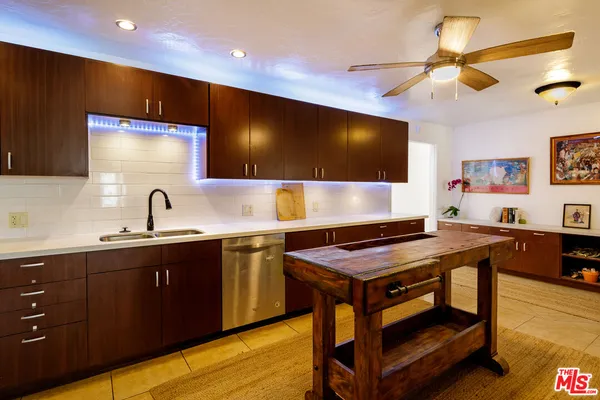a kitchen with stainless steel appliances granite countertop a sink a stove and a refrigerator