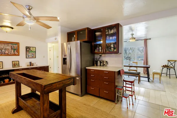 a view of kitchen with stainless steel appliances kitchen island dining table and chairs
