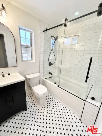 a bathroom with a sink a toilet and shower