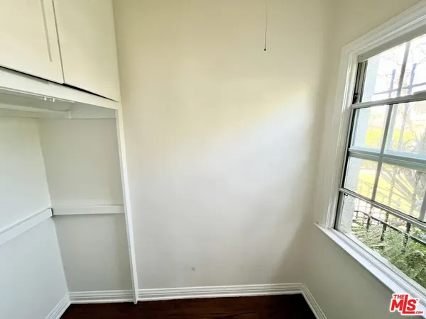 a view of small space with wooden floor and a window