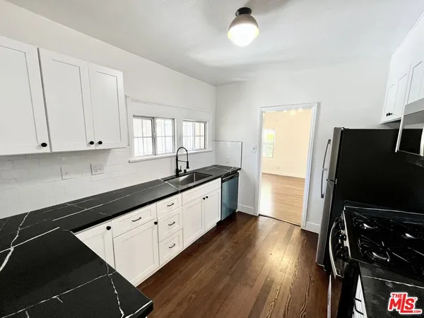 a large kitchen with a window and stainless steel appliances