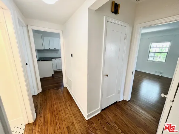 a view of a hallway with wooden floor and staircase