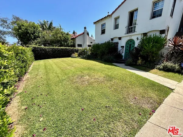 a view of a yard with plants and brick building