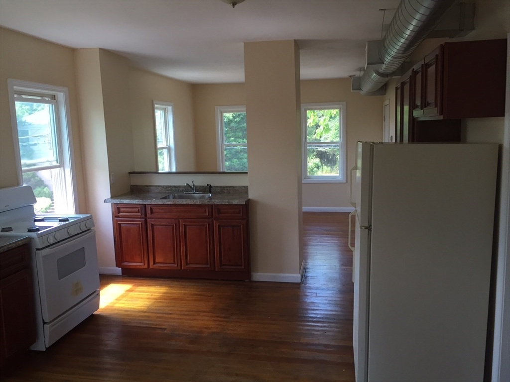 52 Winter Street Taunton, MA 02780 - Photo 9 of 21 a kitchen with kitchen island granite countertop wooden floors and wide window